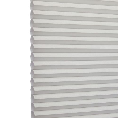 White cellular (honeycomb) blind, left-edge visible with uniform horizontal pleats; fully lowered and closed, softly filtering daylight; set against a bright, neutral interior background.
