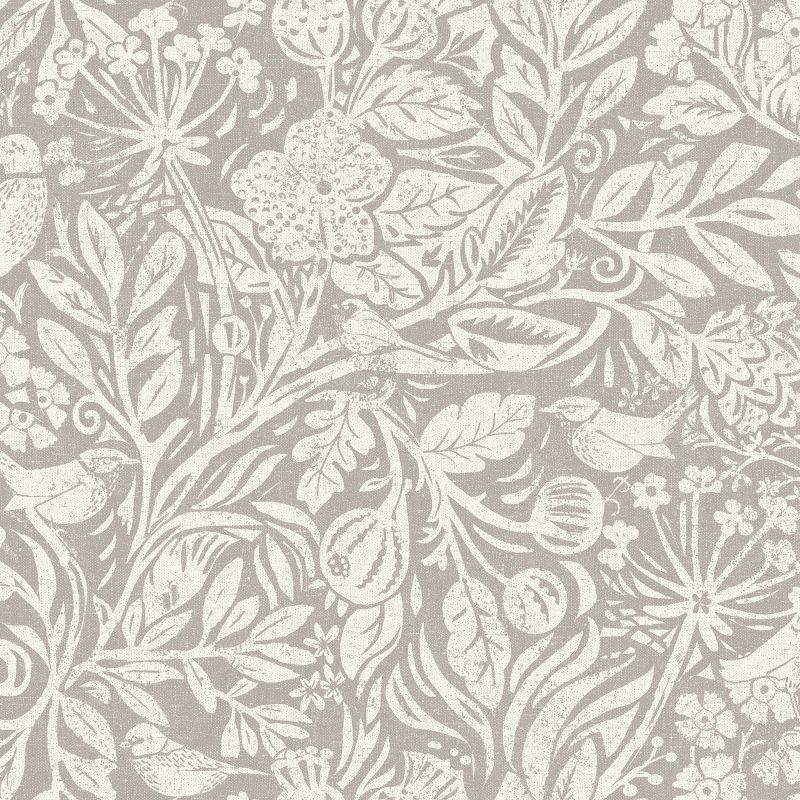 Beige wallpaper with cream, distressed botanical printâ€”stylized leaves, flowers, seed pods and small birdsâ€”decorating a surface; close-up view with even, neutral lighting.
