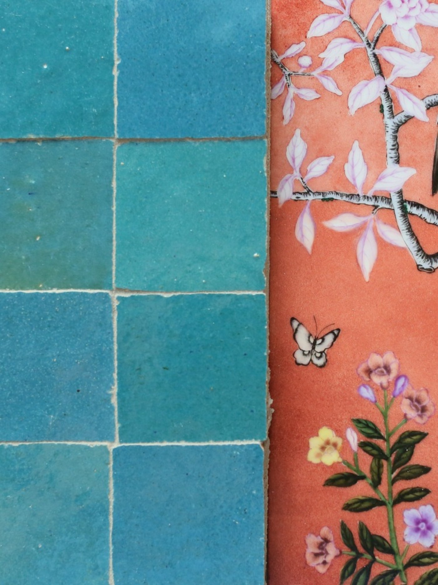 blue tile next to a wall with flower patterns on it.