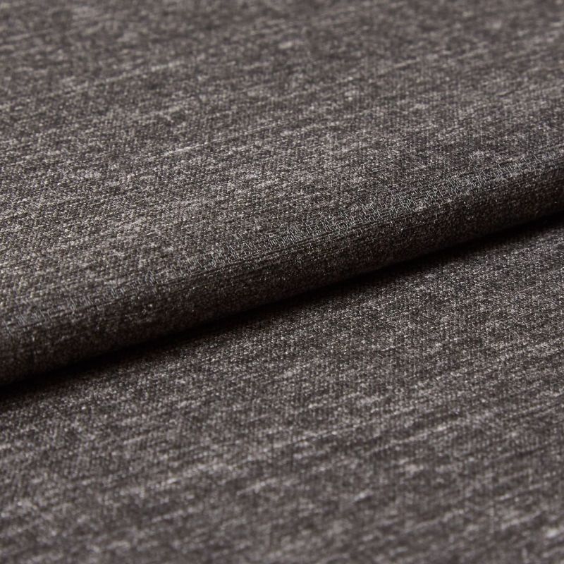 Dark gray woven upholstery fabric, folded with an overlapping edge, showing subtle metallic sheen and fine horizontal texture; close-up view under soft studio lighting against a neutral backdrop.