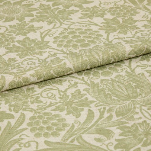 Green-and-cream floral-patterned fabric, folded with an overlapping edge, displaying woven texture and grape-and-leaf motifs; close-up studio shot with soft, even lighting suggesting an upholstery or curtain sample.