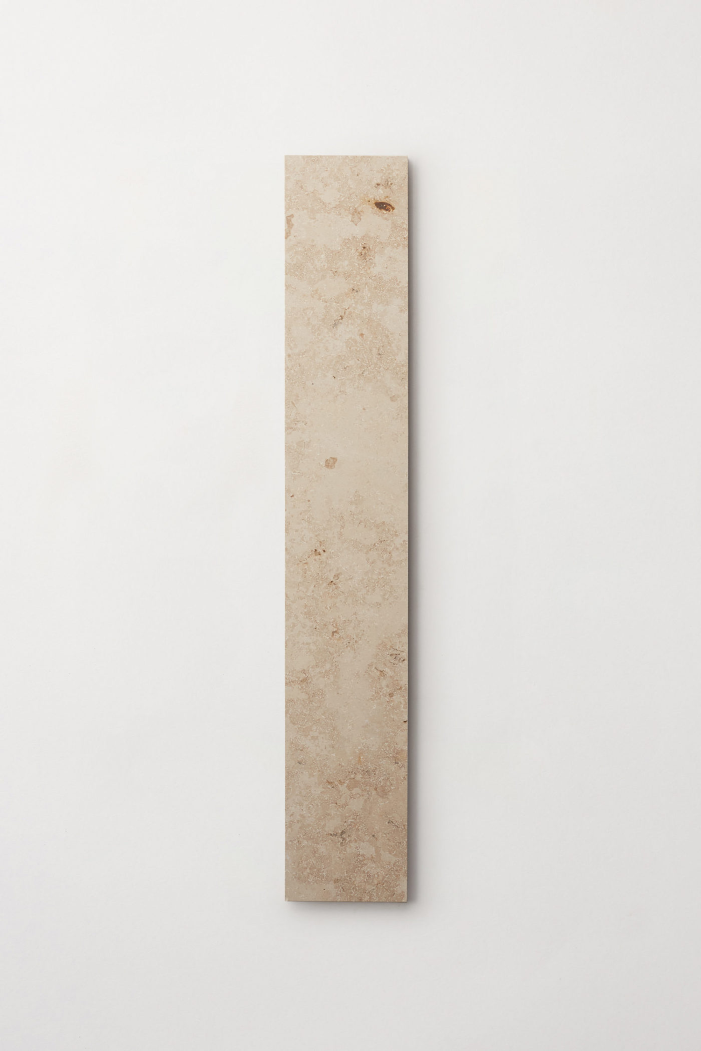 a rectangular limestone tile on a white surface.