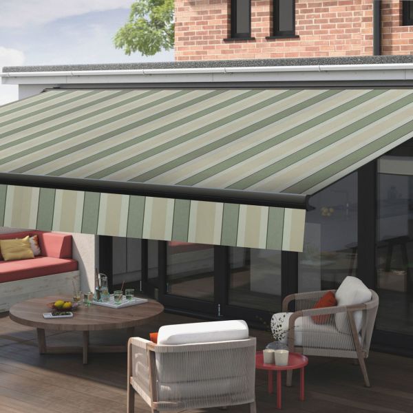 Striped retractable fabric awning, green and beige diagonal stripes, fully extended over patio; shading the sliding glass doors and outdoor seating area with modern chairs, wooden table, and daytime light.