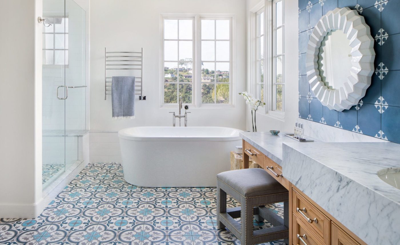 a bathroom with blue and white tile and a tub.