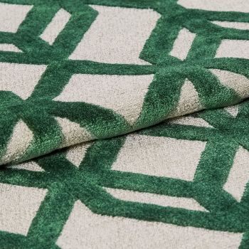 Tufted rug with raised green geometric lattice on a beige ground â€” folded to show pile and backing â€” close-up, studio-lit textile sample highlighting textured fibers and overlapping layers.