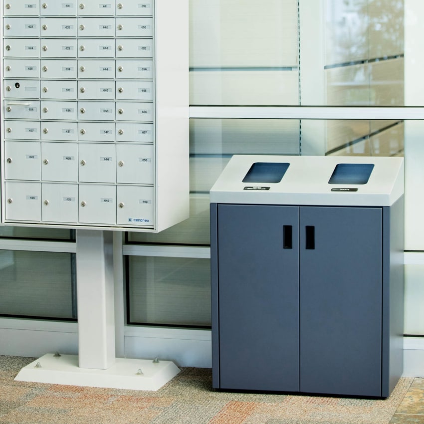 double stream trash and recyclables bin in the entrance of a corporate office sitting beside a mail box
