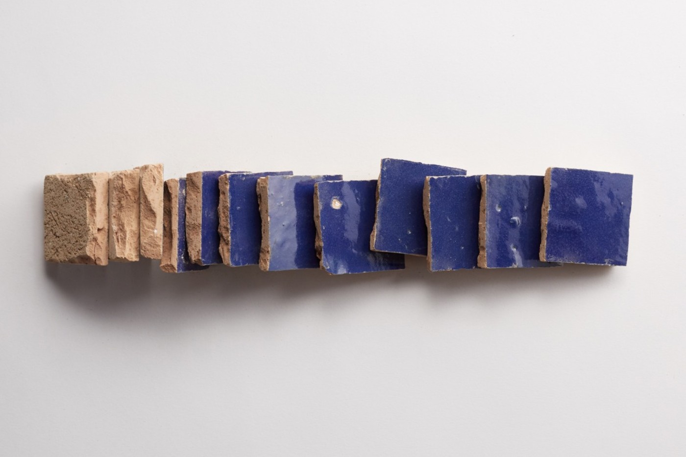 a stack of blue tiles on a white surface.