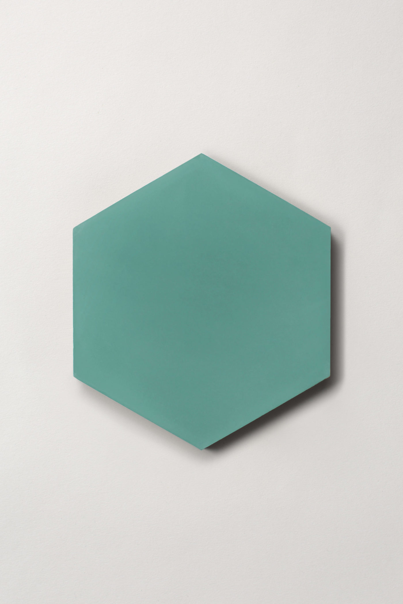 a teal hexagonal tile on a white surface.