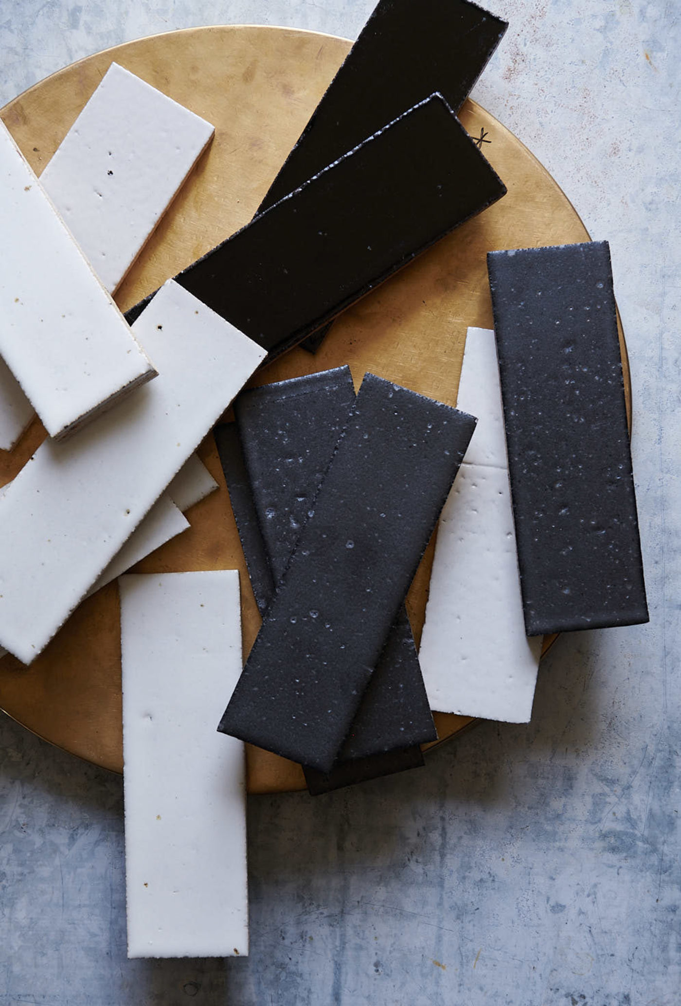 a set of white and black rectangle tiles scattered on a grey and brown surface.