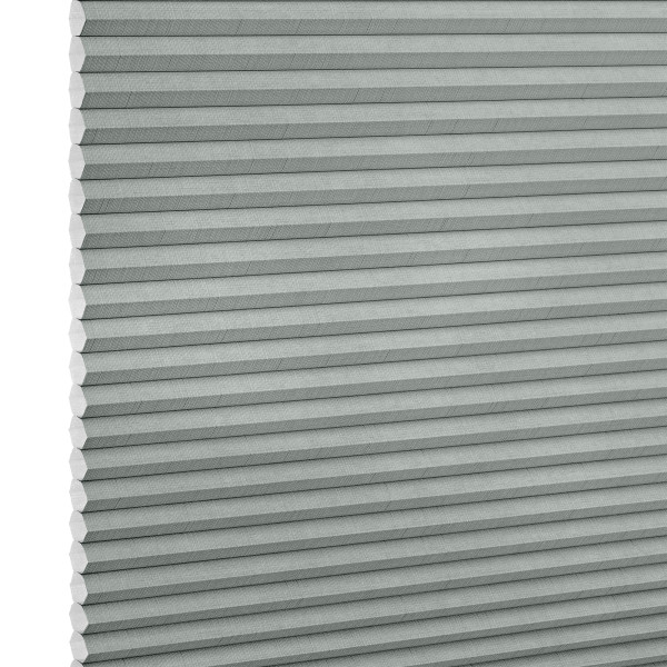 Light-gray pleated cellular (honeycomb) blind, tightly closed with visible hexagonal cells at left edge; filtering/diffusing light, photographed close-up filling the frame against a white background.