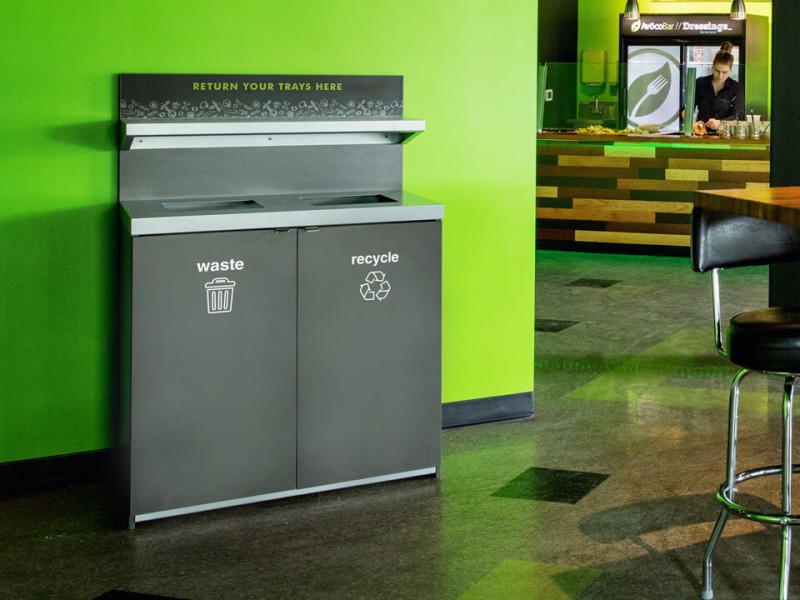 double stream waste and recycling container made from composite board for restaurants including a shelf for food trays in a busy restaurant