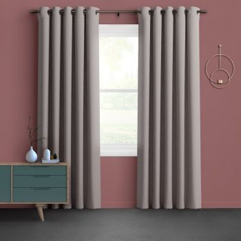 Grommet-top beige floor-length curtains, hung in even folds on a metal rod and partially open, filtering soft daylight through a white-trim window in a muted-rose living room.