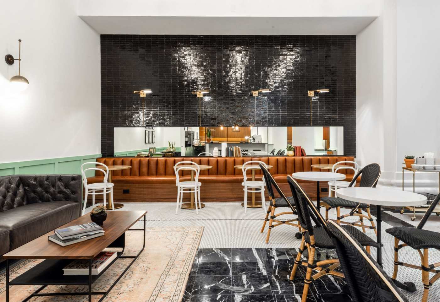 the interior of a coffee shop with a black tiled wall.