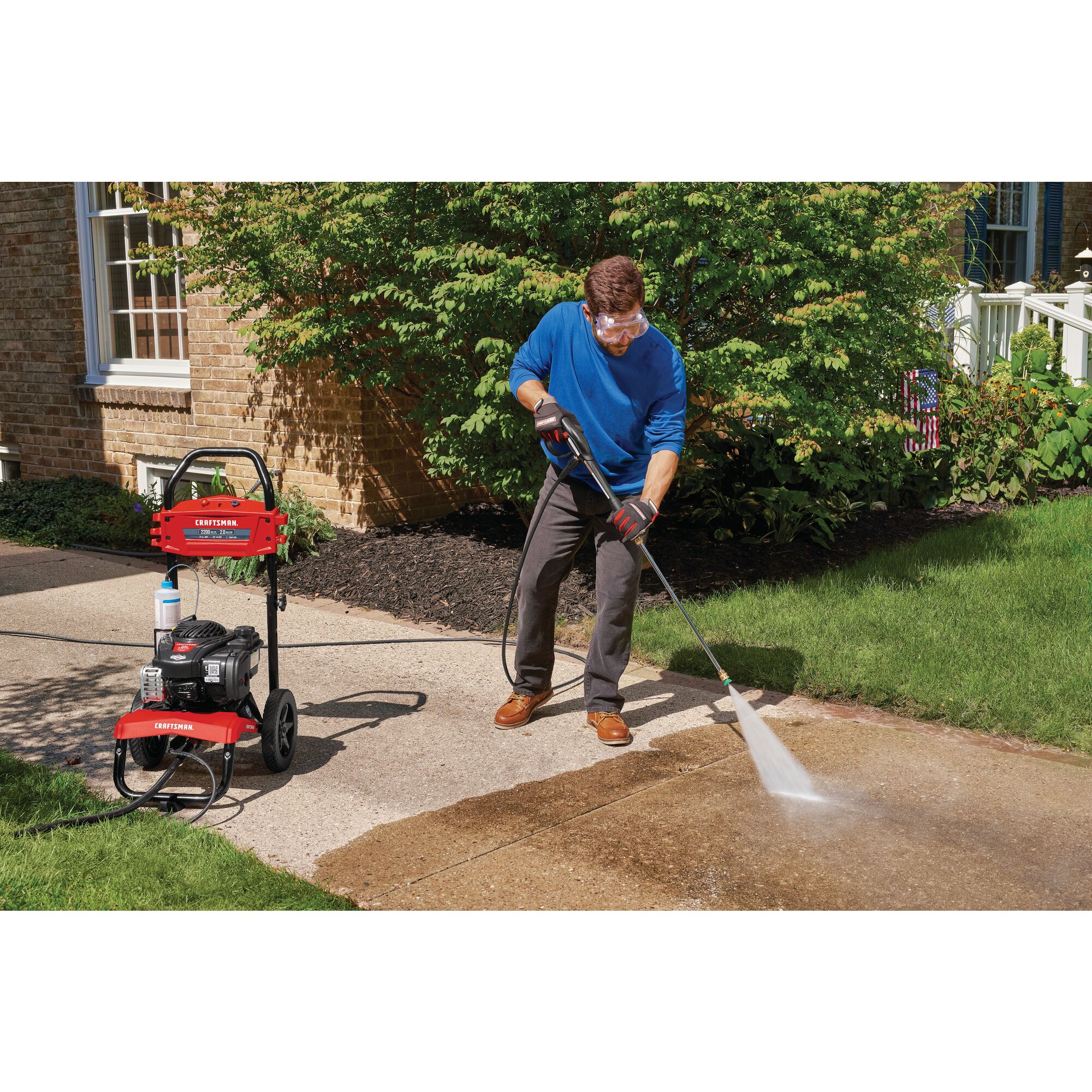 2200 MAX Pounds per Square Inch or 2 MAX Gallons Per Minute Pressure Washer being used by person to wash pavement in outdoor lawn.