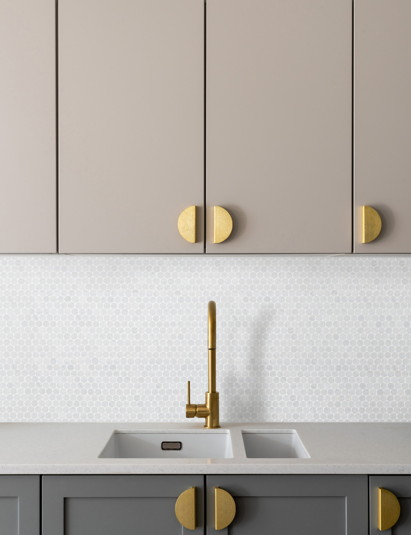 a kitchen with grey cabinets and gold handles.