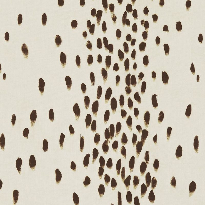 Cream fabric patterned with irregular brown brushstroke ovals â€” clustered centrally and scattered outward â€” covering a flat surface under even, neutral lighting, resembling abstract textile or wallpaper.