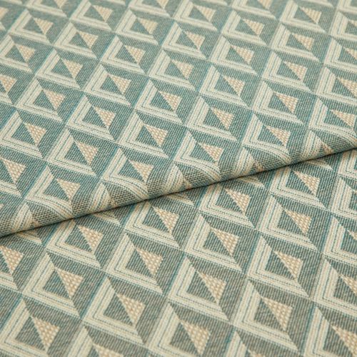 Woven geometric upholstery fabric, teal and beige diamond-triangle pattern, folded once across center, showing textured weave and repeating motifs; close-up, neutral soft lighting, studio-style flat lay.