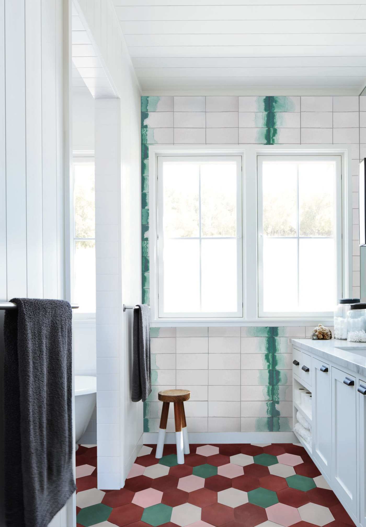 a bathroom with a green and pink tiled floor.