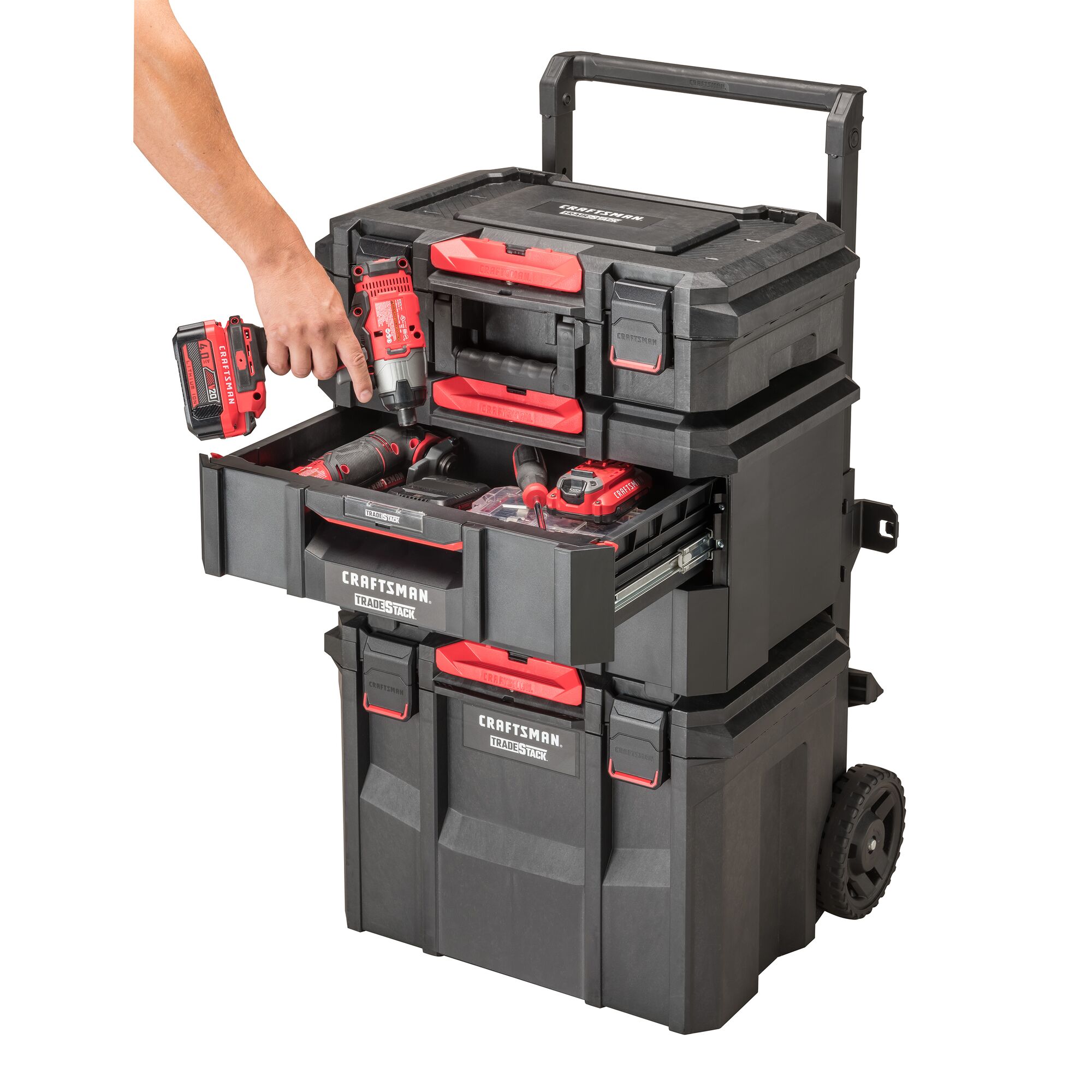CRAFTSMAN TRADESTACK 2-Drawer Unit placed in the middle of a TRADESTACK Tower, between a TRADESTACK Rolling Unit and TRADESTACK Suitcase, with hand placing CRAFTSMAN impact driver into opened top drawer