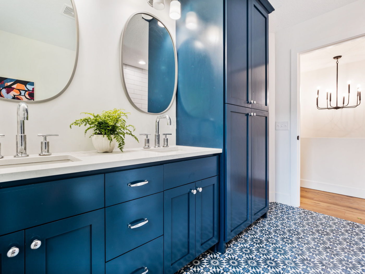 a bathroom with blue cabinets and a mirror.