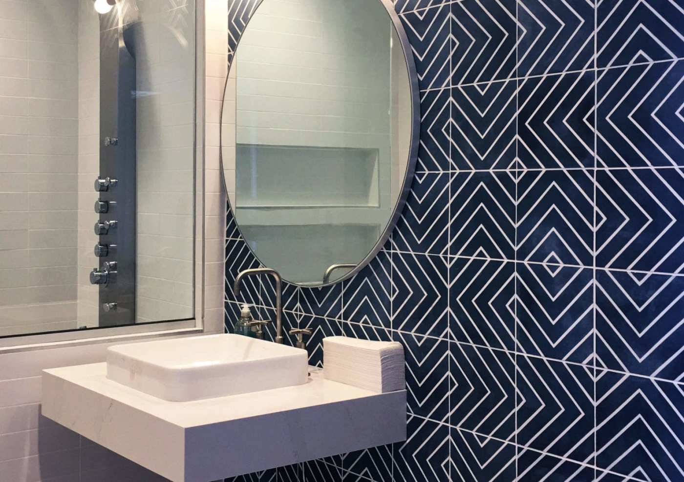 a bathroom with a blue and white tiled wall.