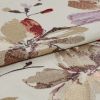 Folded cream jacquard fabric with metallic beige, mauve and red floral motifs â€” layered to reveal raised sheen and woven texture â€” close-up on flat surface under soft, even lighting.