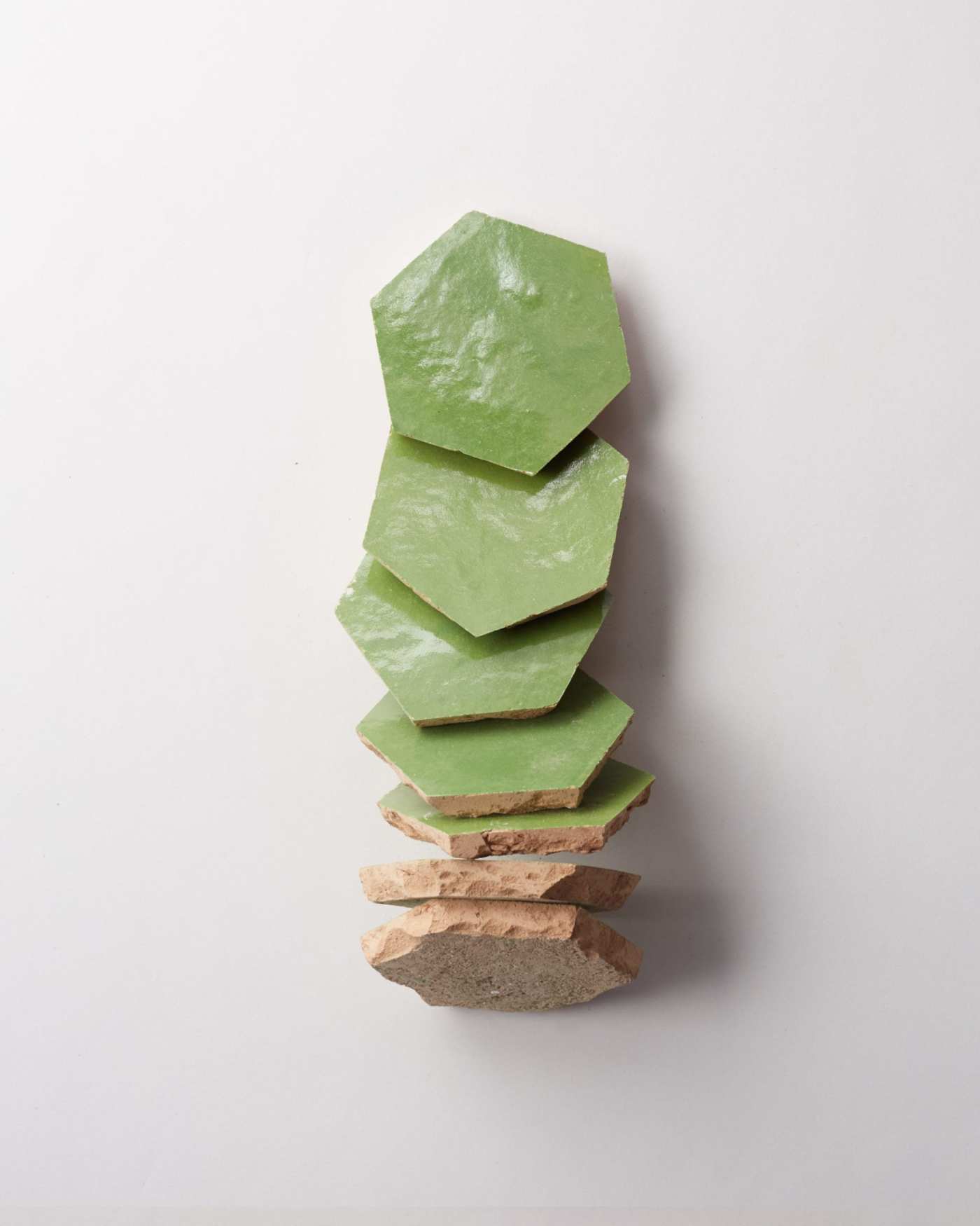 a stack of green hexagonal tiles on a white background.