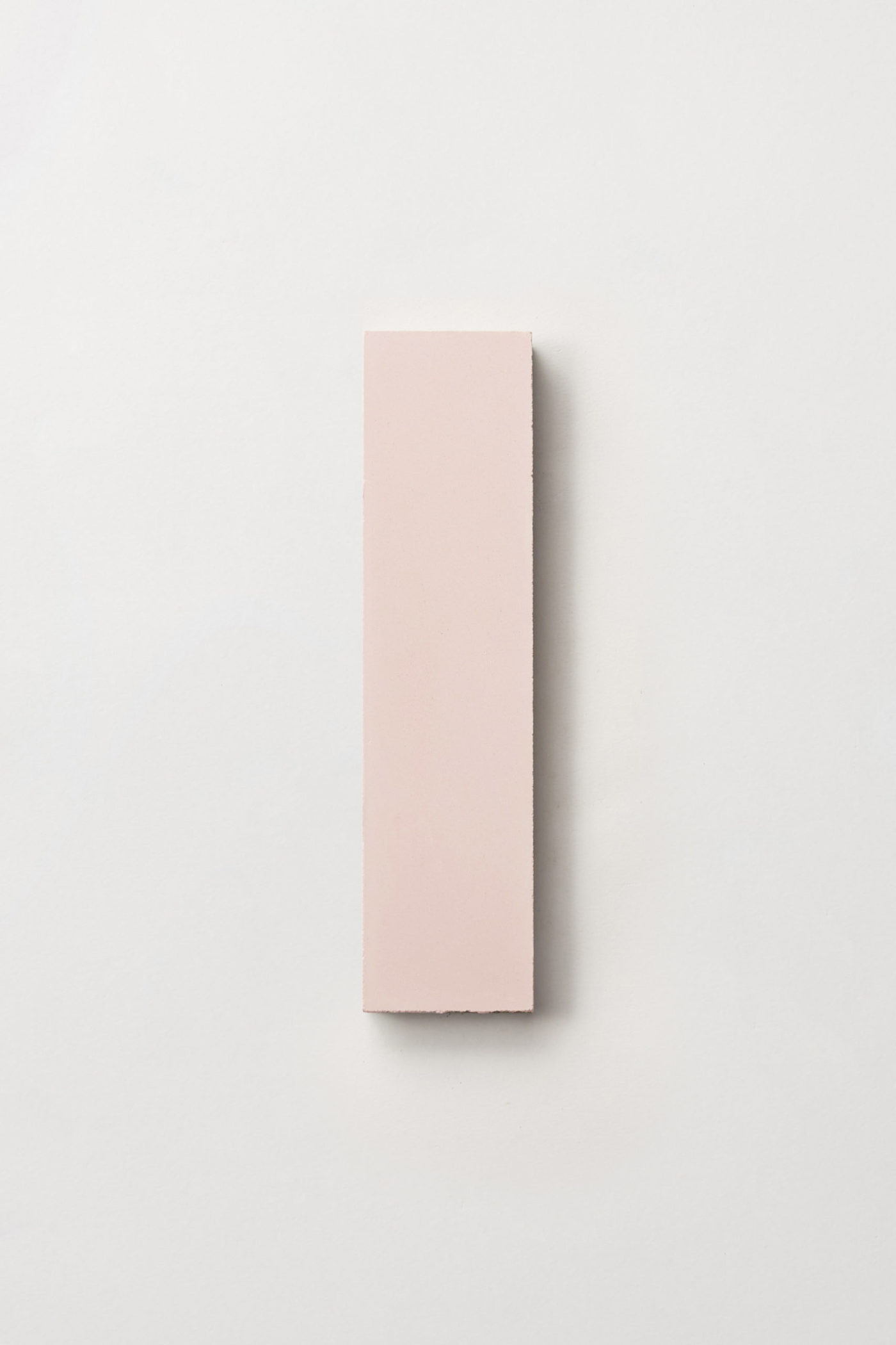 a pink rectangle tile on a white surface.