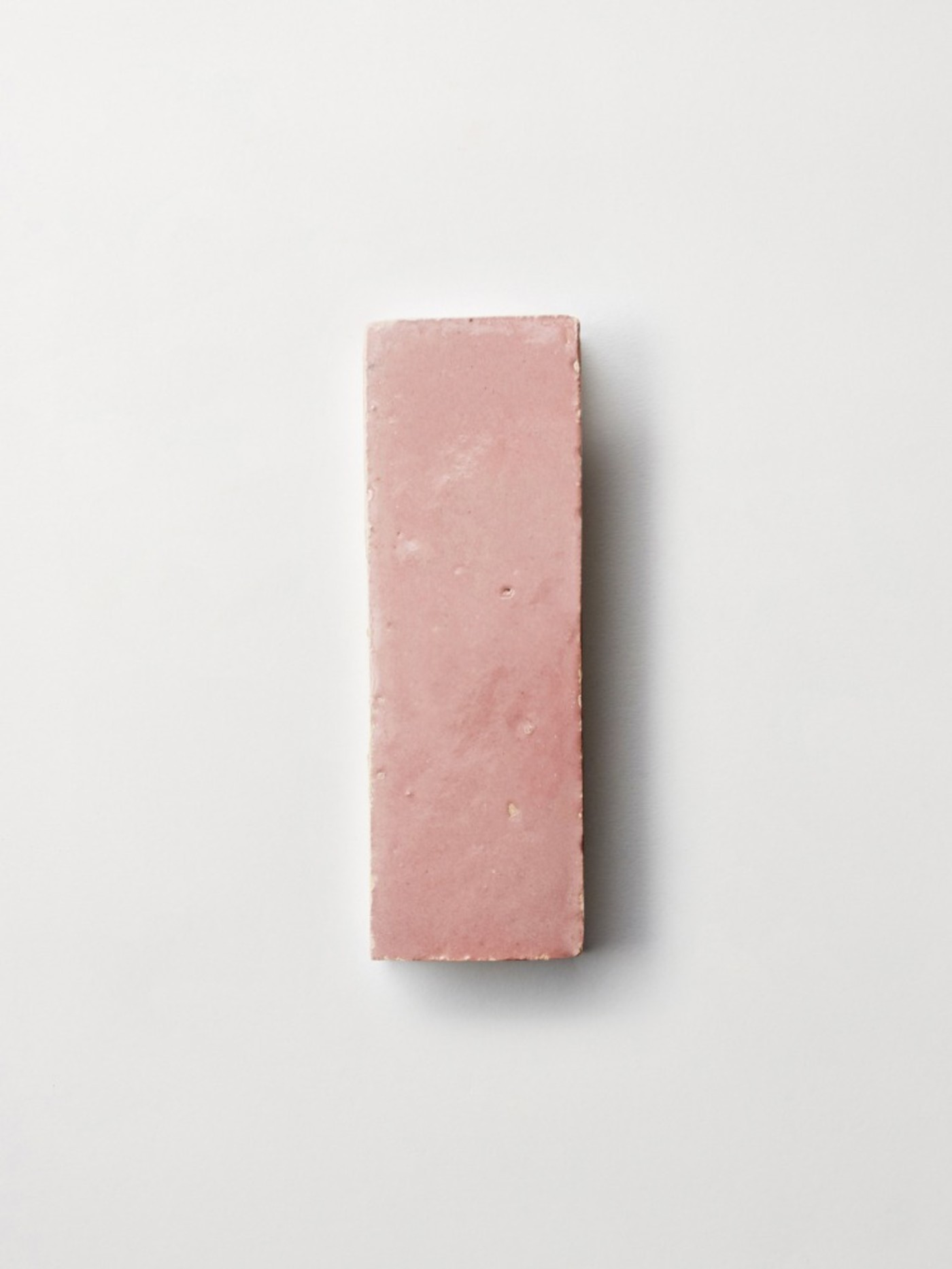 a pink tile on a white surface.