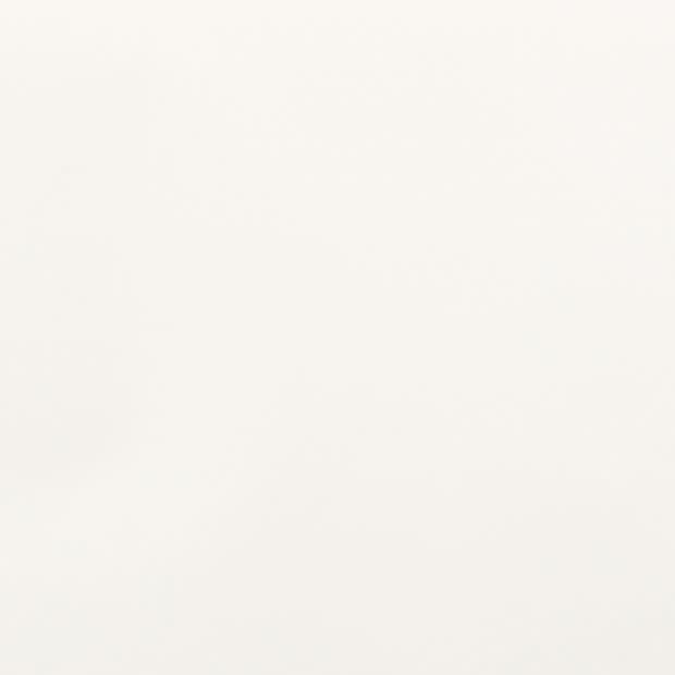 Blank off-white surface, smooth and slightly textured, occupying the entire frame; unadorned and static, evenly lit by neutral indoor light with no visible features or objects.