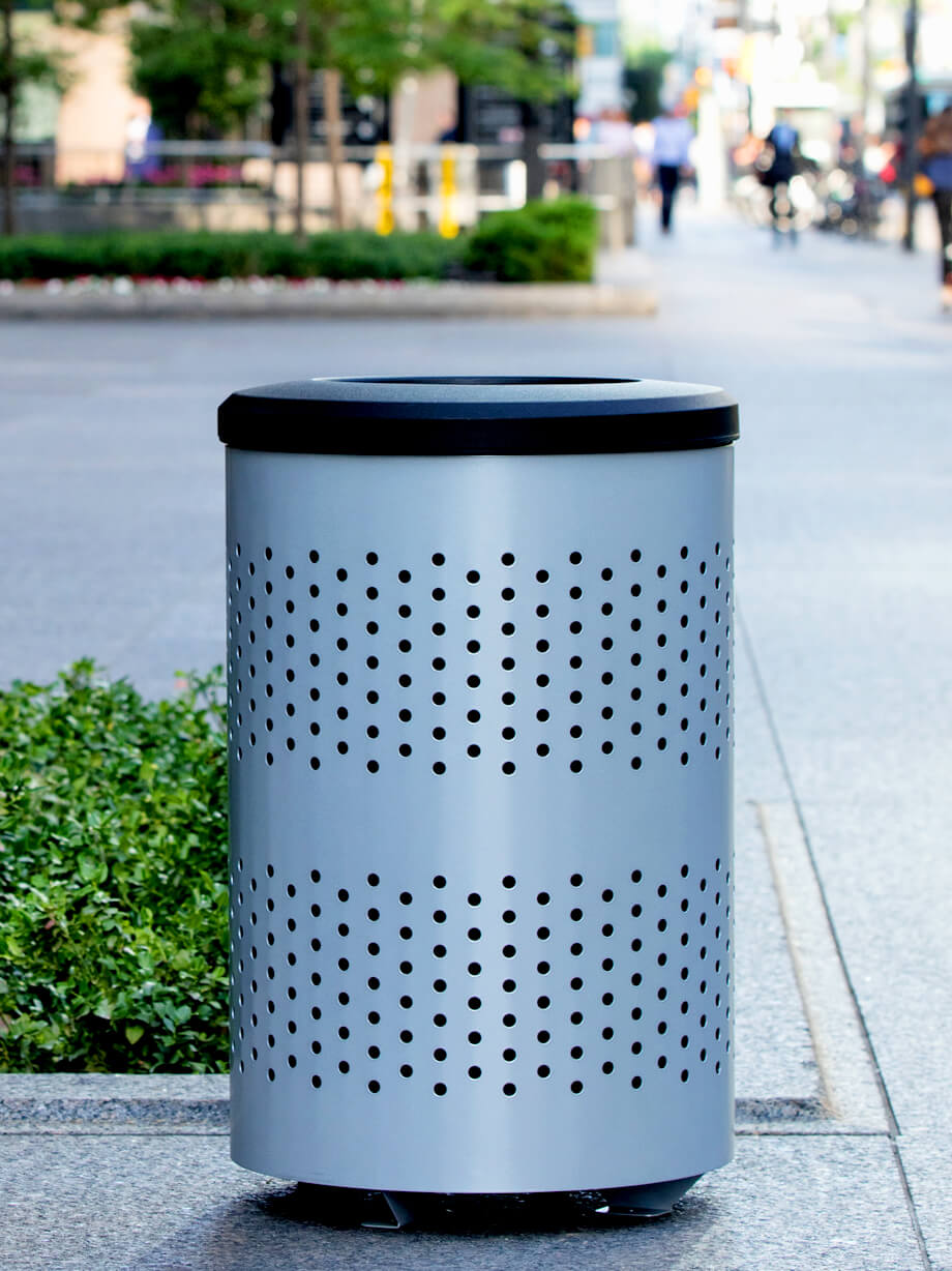 silver metal outdoor trash container with large capacity liner and black plastic lid on a busy city sidewalk