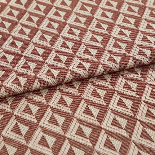 Woven upholstery fabric with repeating terracotta-and-cream triangular motif, folded once across the frame, revealing textured weave and raised pattern; close-up, evenly lit studio shot on neutral surface.