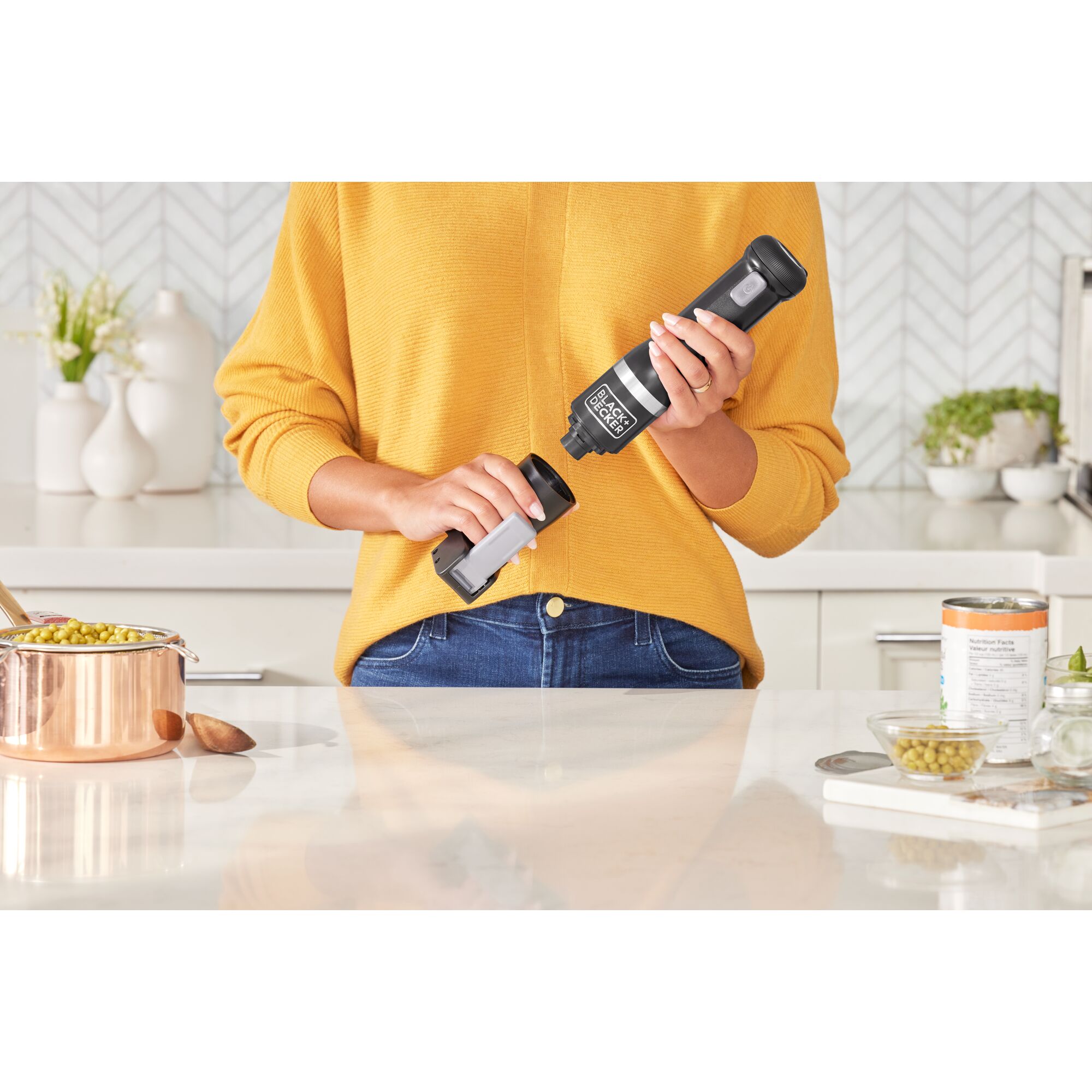 Talent showing how to attach the BLACK+DECKER kitchen wand can opener attachment to the black power unit