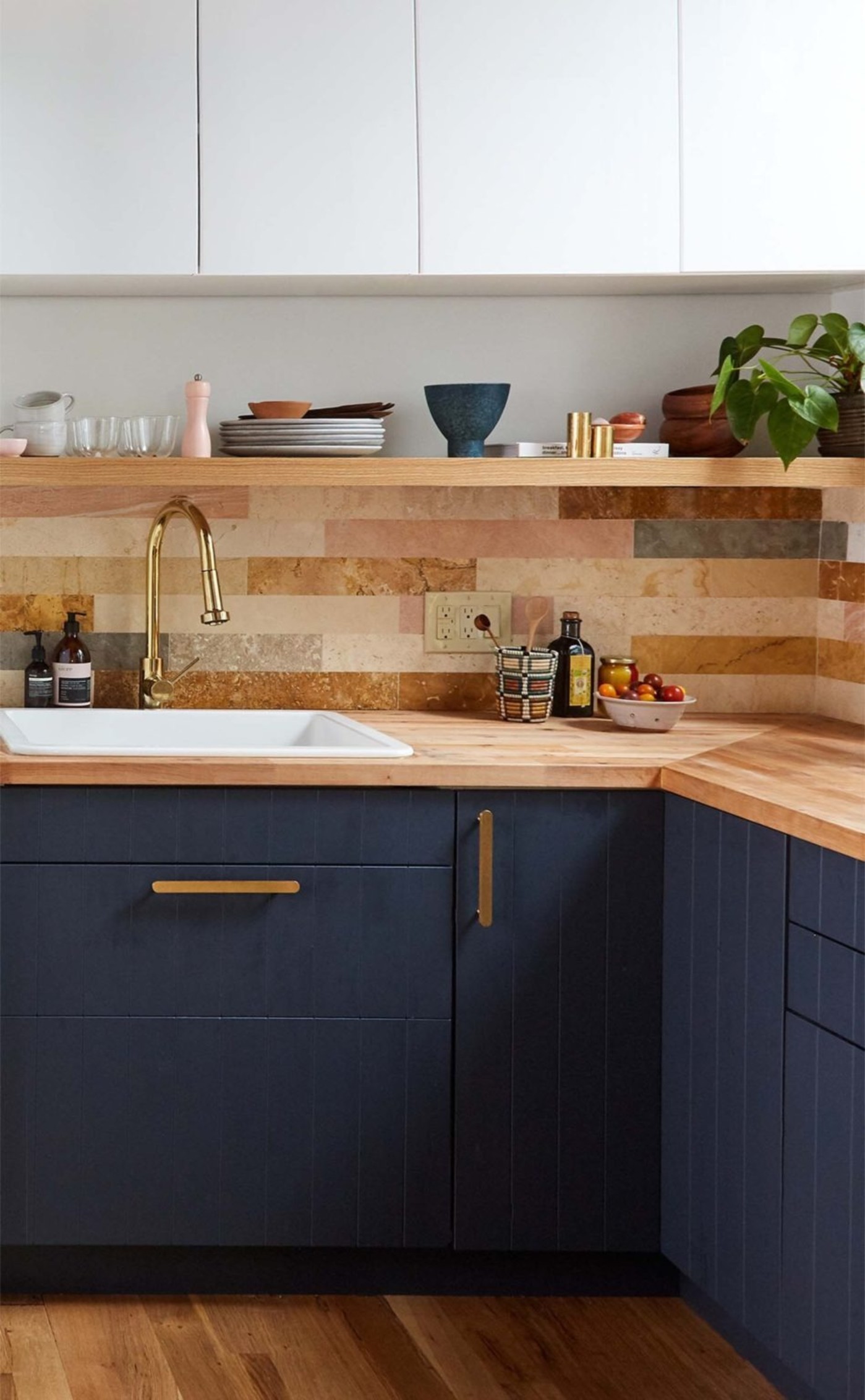 a kitchen with blue cabinets and wooden counter tops.