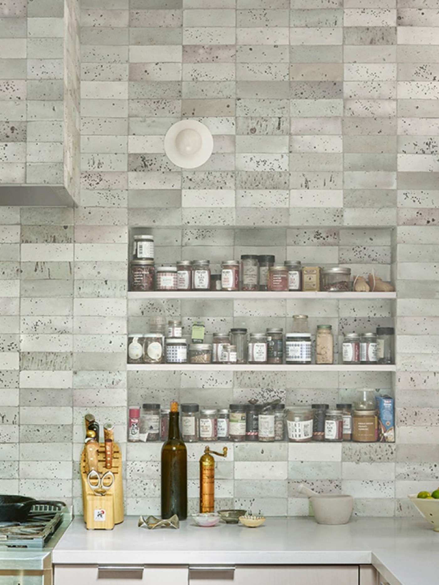 a kitchen with a tiled wall and shelves.