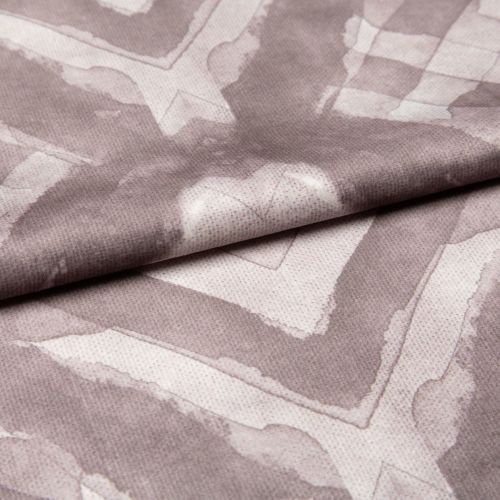 Soft woven fabric with faded mauve geometric frames and subtle heart motif (folded across the center), draped and overlapped to reveal stitched texture, close-up under even studio lighting.