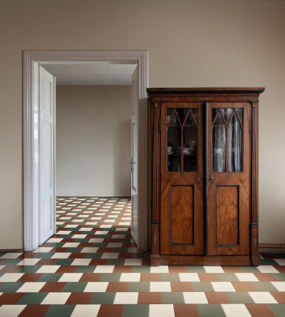 a room with a wooden cabinet and a checkered floor.