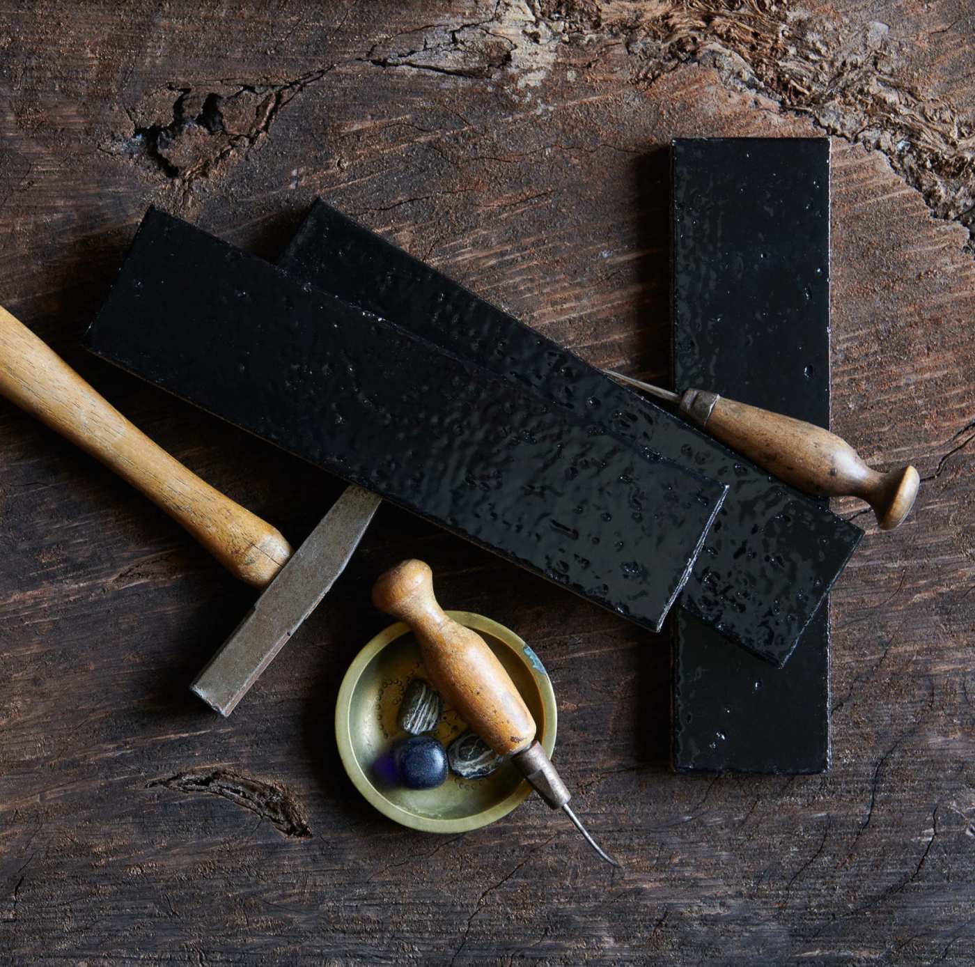 a group of tiles and tools on a natural stone surface.