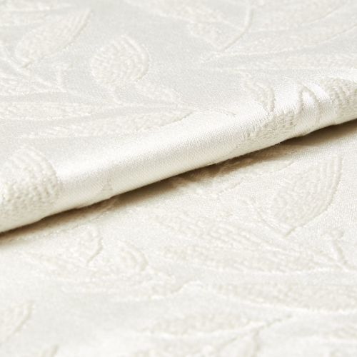 Cream damask fabric with raised floral pattern and satin sheen, shown folded and slightly overlapping; close-up view revealing textured embroidery and soft, diffuse lighting on a neutral surface.