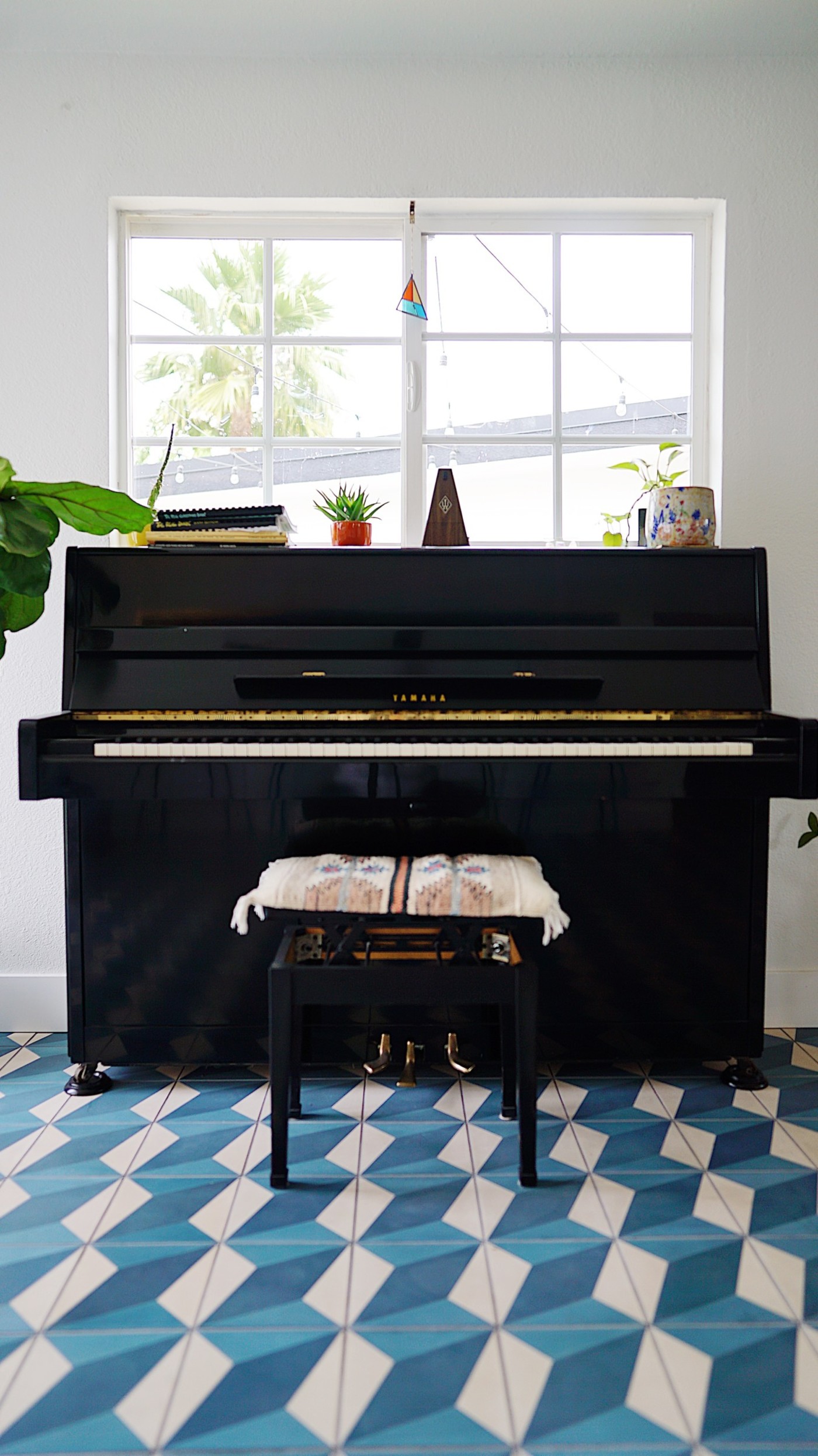 a piano in a room with a blue and white tile floor.