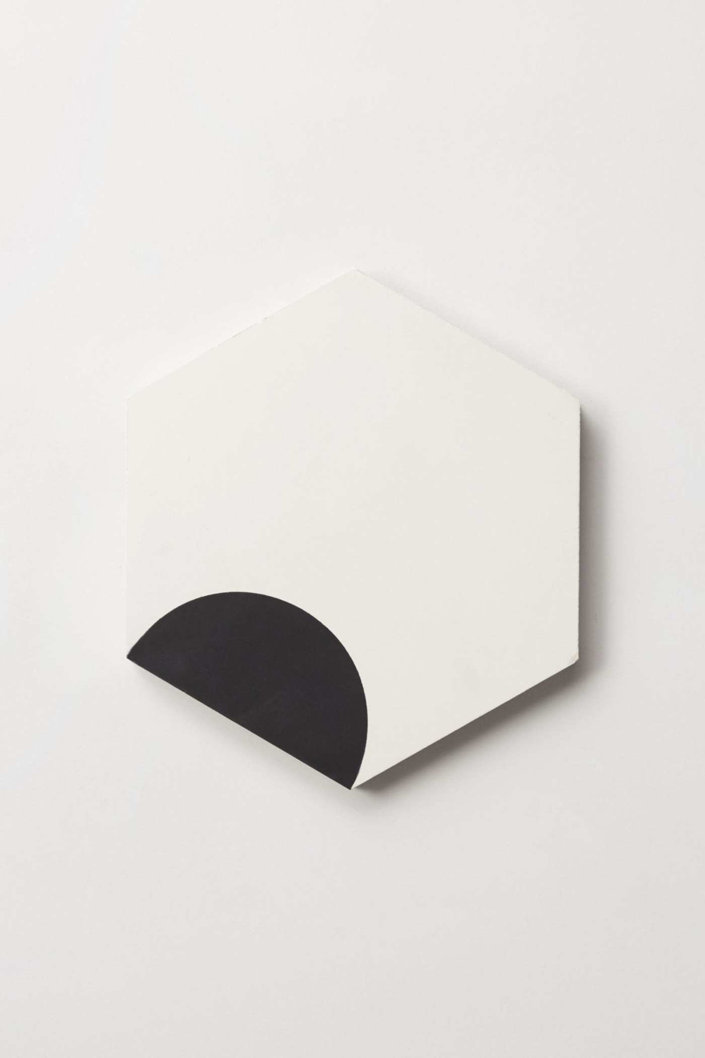 a white and black hexagonal tile on a white surface.