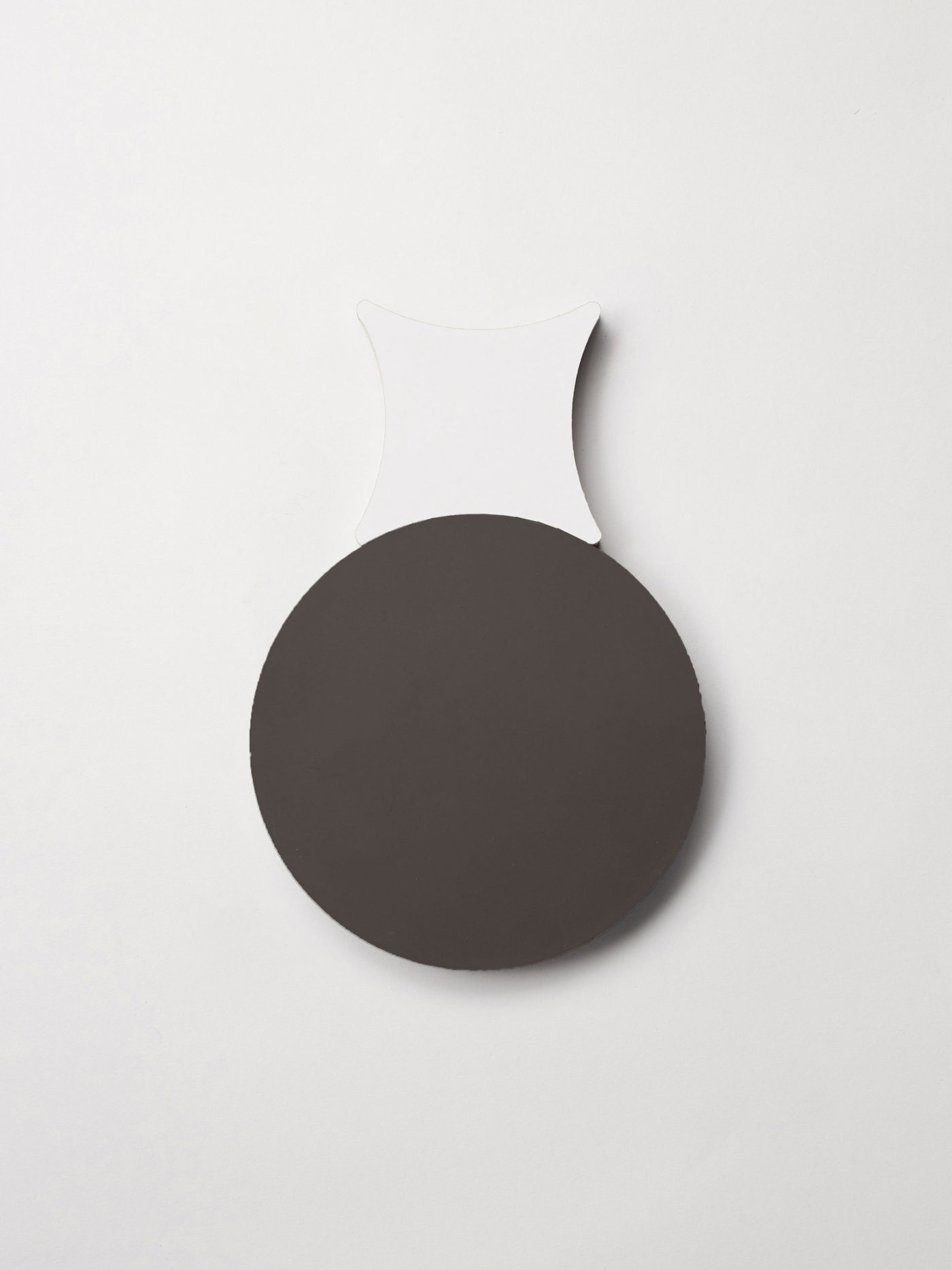 a black circular tile next to a white cross-shaped tile on a white background.