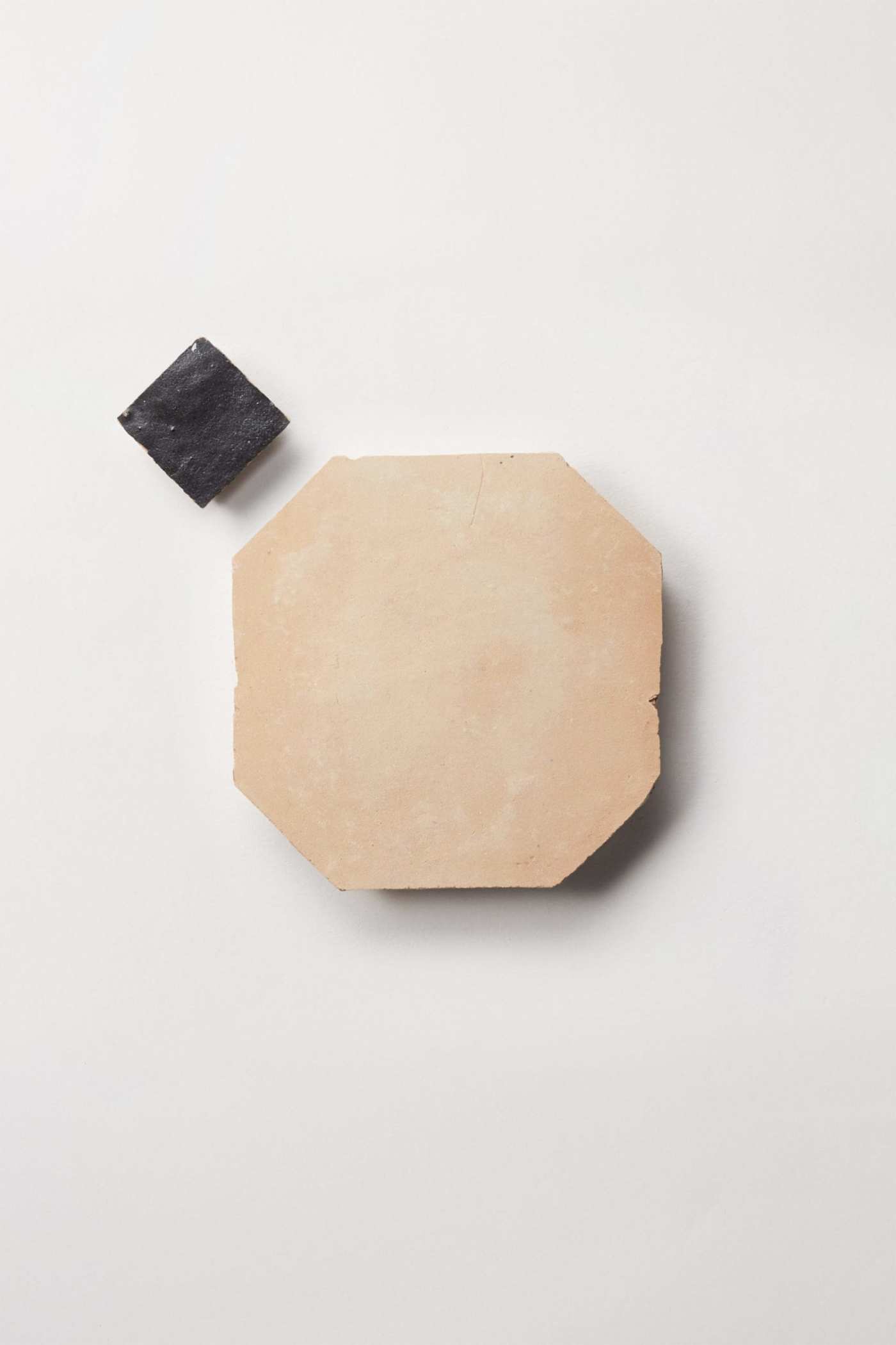 beige and black tiles on a white surface.