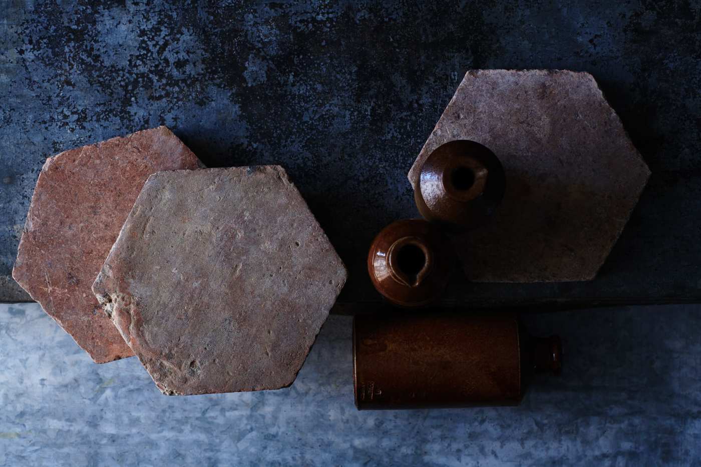 hexagonal terracotta tiles and two vases on a table.