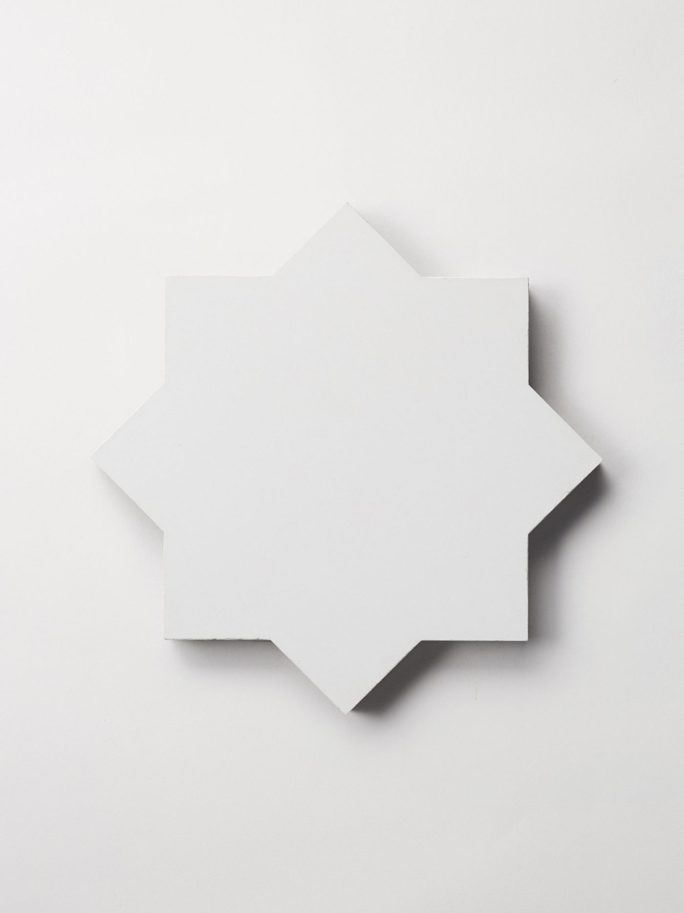 a white tile in the shape of a star on a white background.