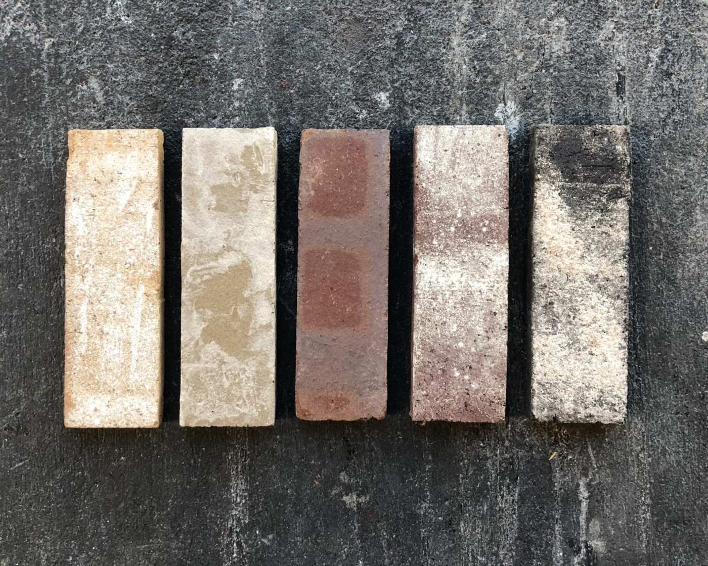 a row of different colored bricks on a black surface.