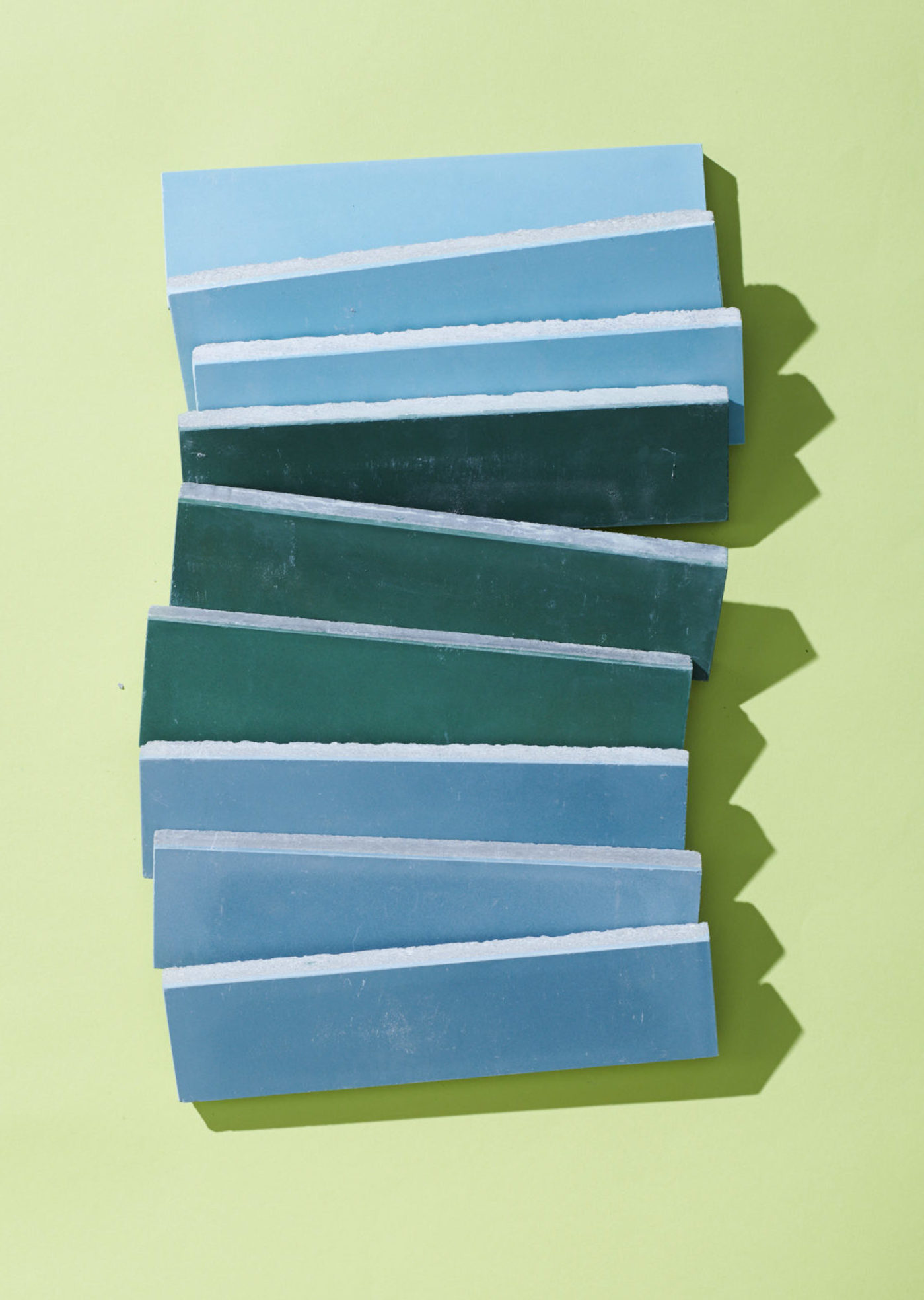 a stack of blue and green tiles on a green surface.