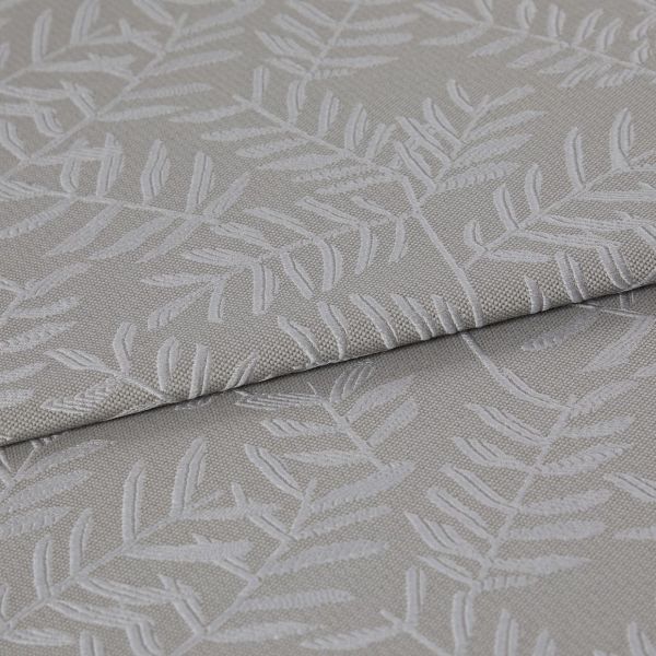 Beige-gray woven fabric with raised white botanical leaf pattern, folded once and layered, displaying texture and subtle sheen; close-up on textile surface under soft, neutral lighting.