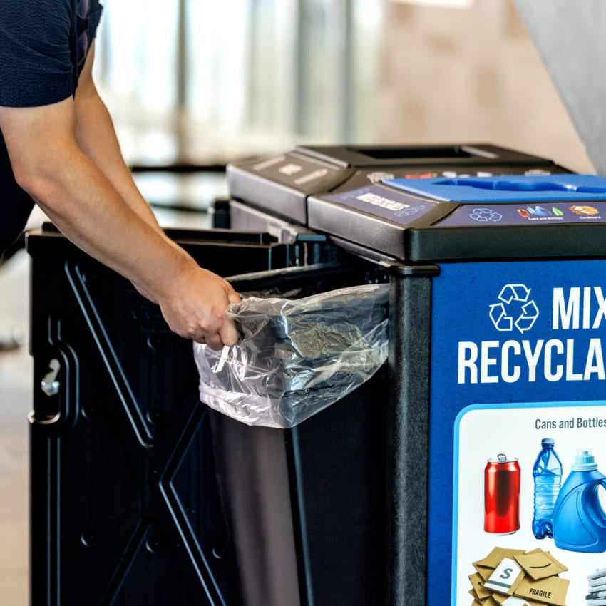 waste and recycling bins with large changeable signs showing a man pulling out the large capacity liner