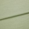 Pale green woven fabric folded once, showing a horizontal overlap and subtle textured weave; lying flat in soft, even studio lighting with a neutral background.